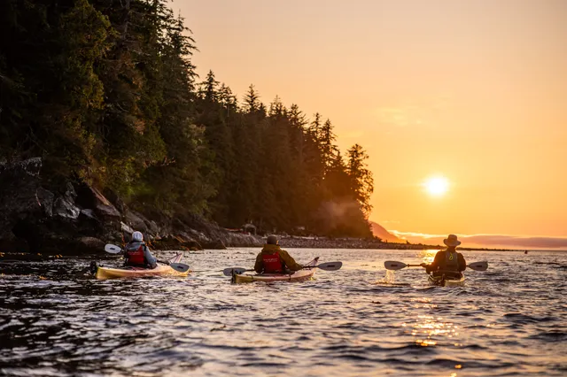 Sea kayakers paddling toward the setting sun