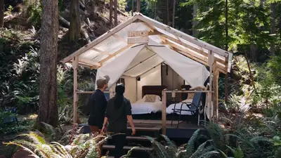 Guests stepping into a canvas-walled cabin in the rainforest