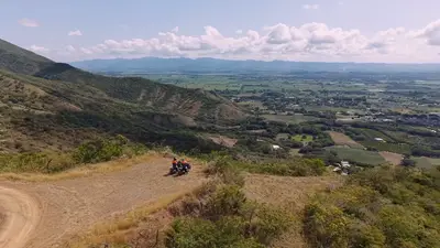 A rider on a dirt track along a ridge