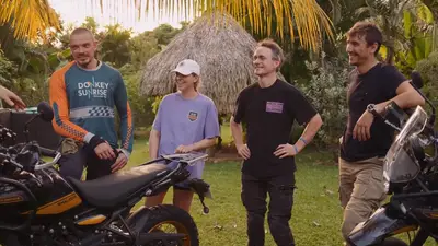 Riders and staff around a bike at the end of the day