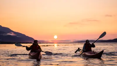Guided sea kayakers on Johnstone Strait at sunset