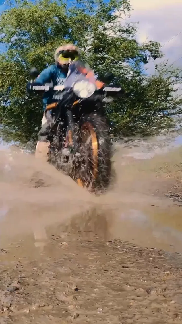 A Himalayan 450 throwing water through a puddle