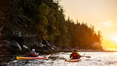 Sea kayakers returning to Orca Camp at sunset on Johnstone Strait