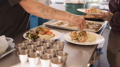 The camp chef plating dinner in the open-air kitchen