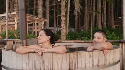 Guests in the wood-fired hot tub among the trees