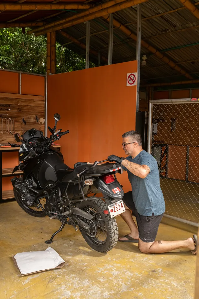 A rider working on his loaded adventure bike in the Donkey Sunrise workshop