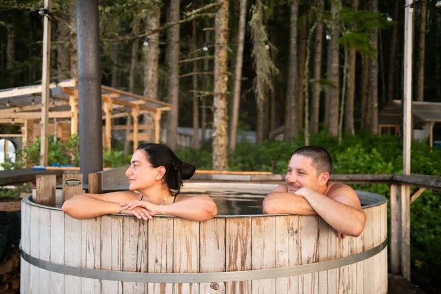 Guests in the wood-fired hot tub among the trees