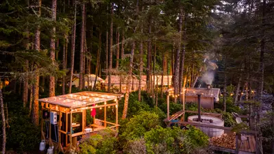 Orca Camp lit at dusk, with wood-fired hot tub and sauna
