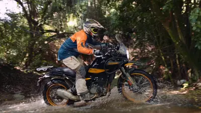 A rider crossing a jungle stream on a Royal Enfield Himalayan 450 near Donkey Sunrise