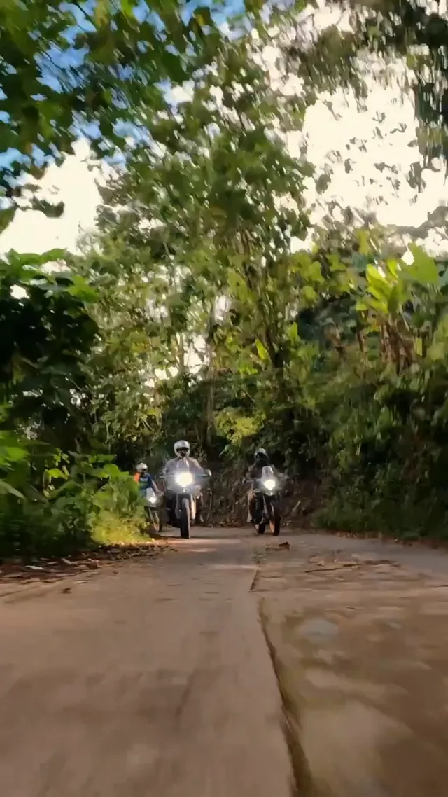 Two riders coming up a jungle road